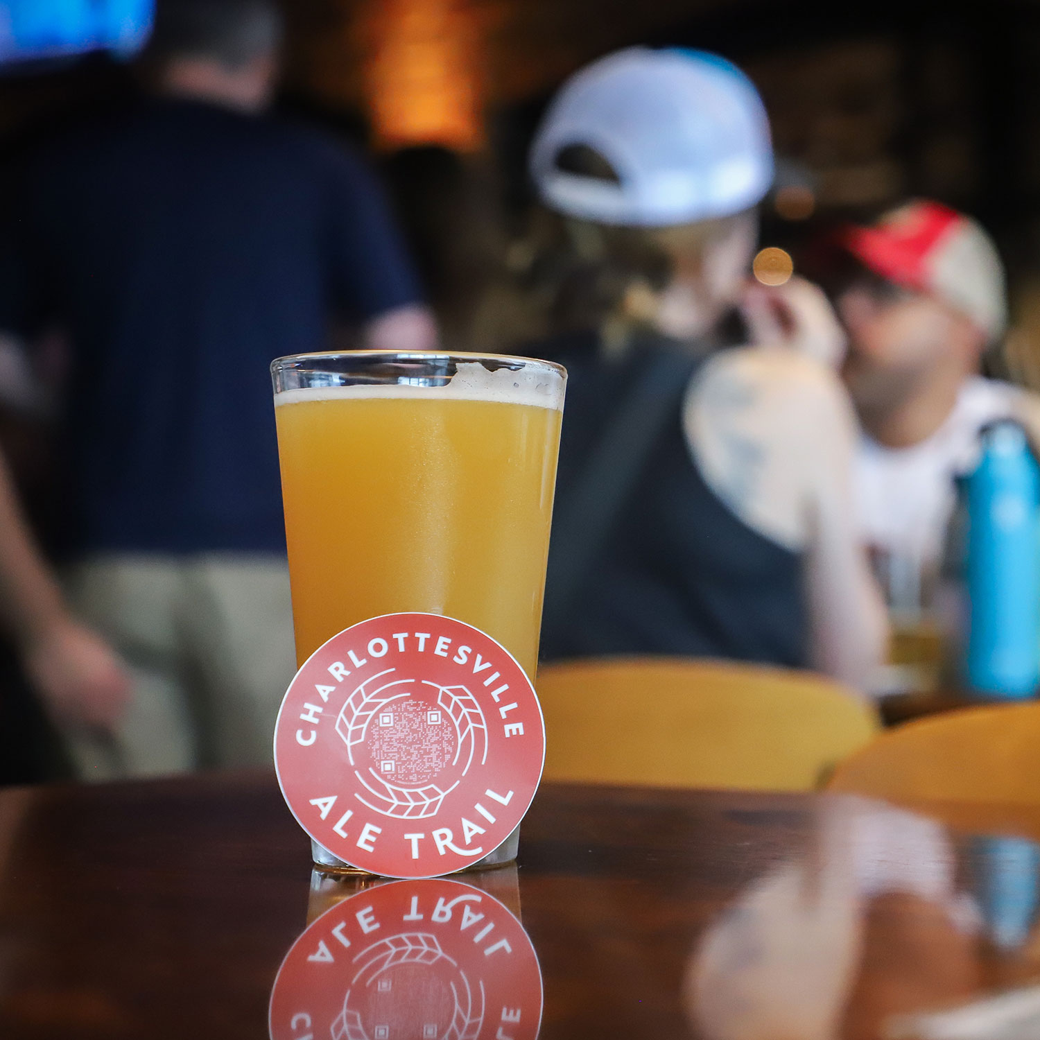 Charlottesville Ale Trail sticker with QR code next to pint glass.